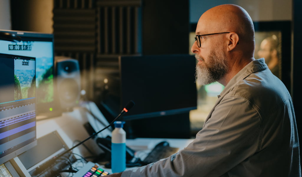 Arno Lubbinge coacht een journalist in een Avid montageset