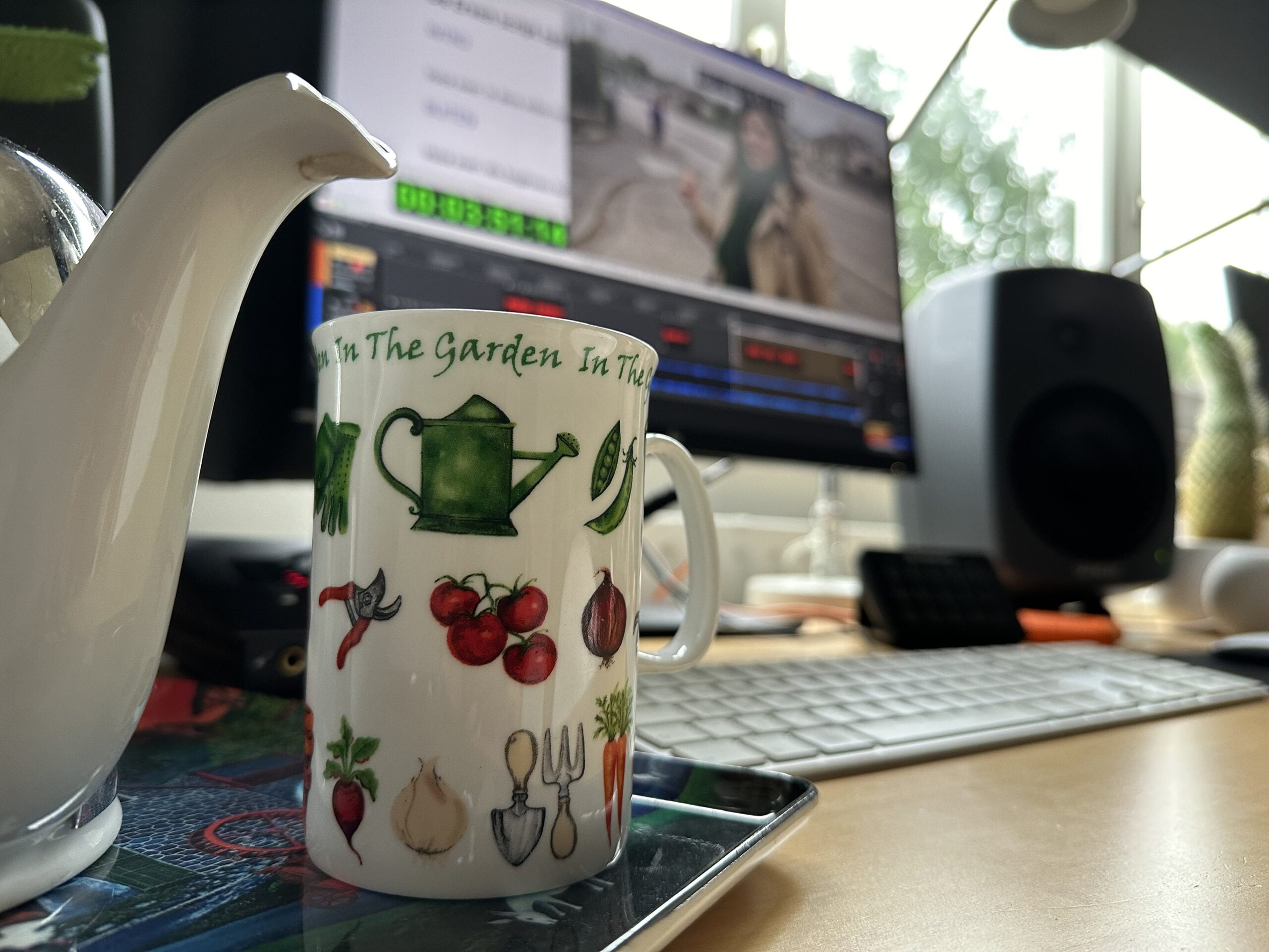 Een kopje thee met op de achtergrond een beeldscherm met het programma 'De Grote Verhuizing'.