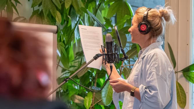 vrouwelijke stemacteur achter de microfoon